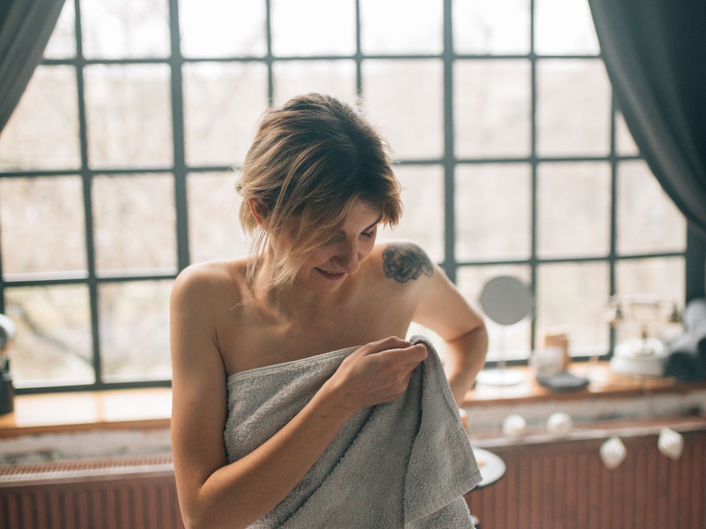 A person resting on a massage table, wrapped in a towel.